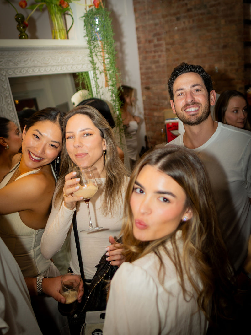 Friends chatting beside the exposed brick and artwork during a LeTish celebration