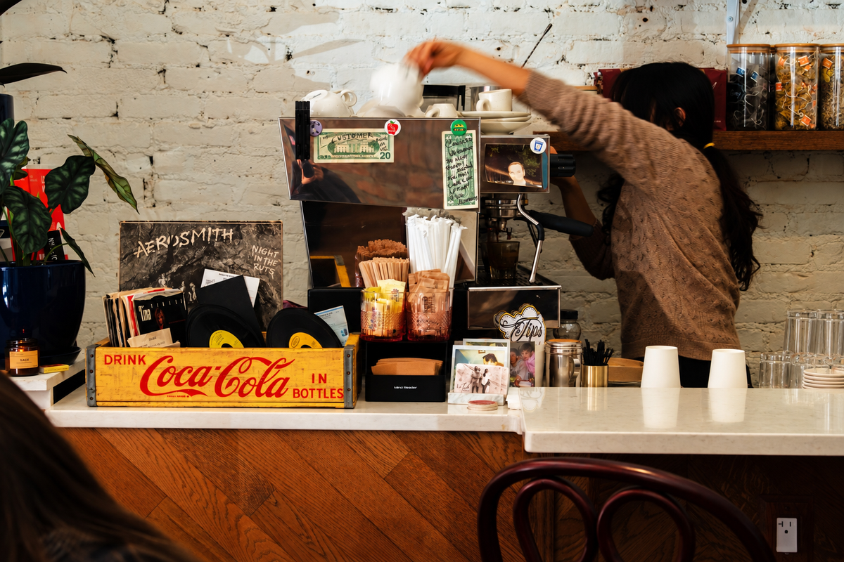 A LeTish barista at the espresso machine behind the café counter