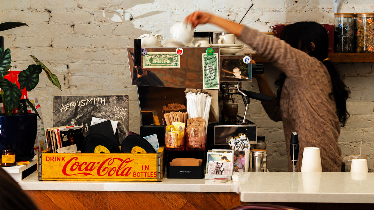 A LeTish barista at the espresso machine behind the café counter
